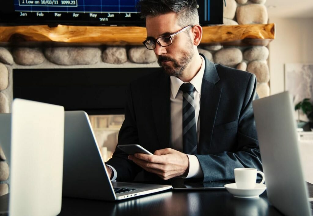 businessman working with laptop and checking phone